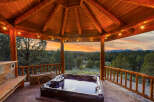 Relax and unwind in this stunning outdoor oasis! This property features a luxurious hot tub nestled under a beautiful wooden gazebo, perfect for enjoying the breathtaking sunset views.