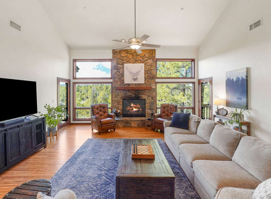 Step into luxury with this stunning living room, featuring a cozy fireplace and expansive windows that frame breathtaking views.