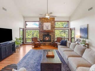 Step into luxury with this stunning living room, featuring a cozy fireplace and expansive windows that frame breathtaking views.