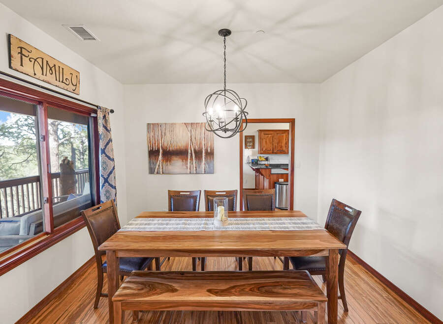 This stunning dining room features a beautiful wooden table and bench, perfect for family gatherings.