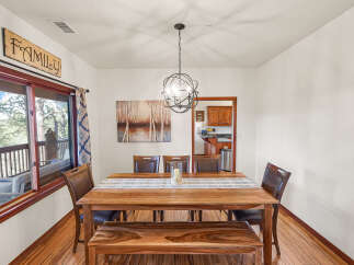 This stunning dining room features a beautiful wooden table and bench, perfect for family gatherings.