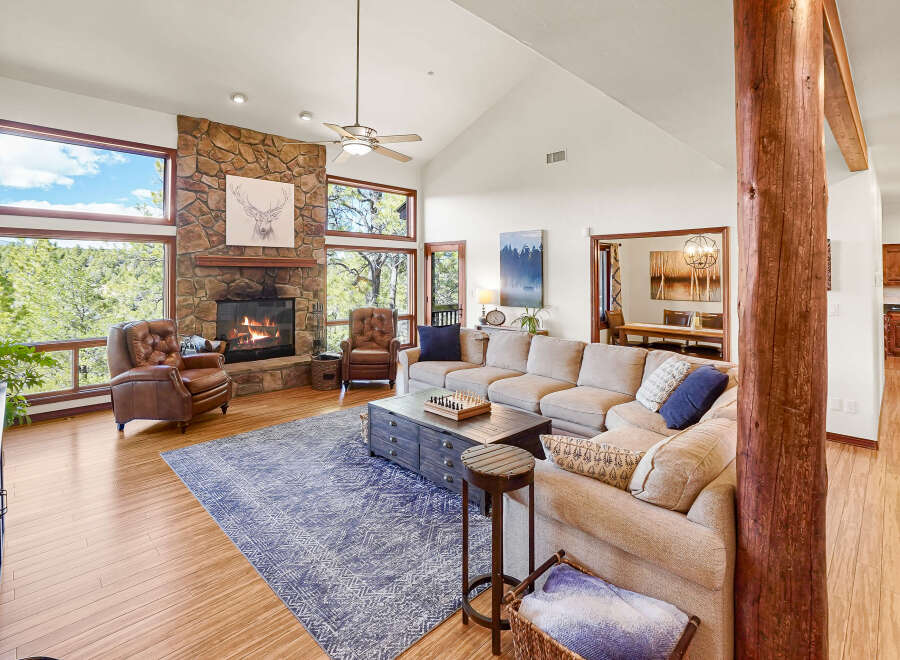 Step into luxury with this stunning living room, featuring a cozy fireplace and expansive windows that frame breathtaking views.