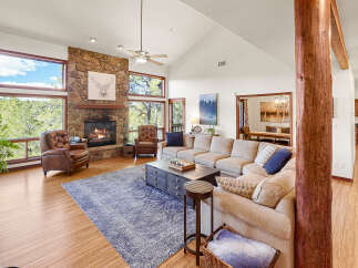 Step into luxury with this stunning living room, featuring a cozy fireplace and expansive windows that frame breathtaking views.