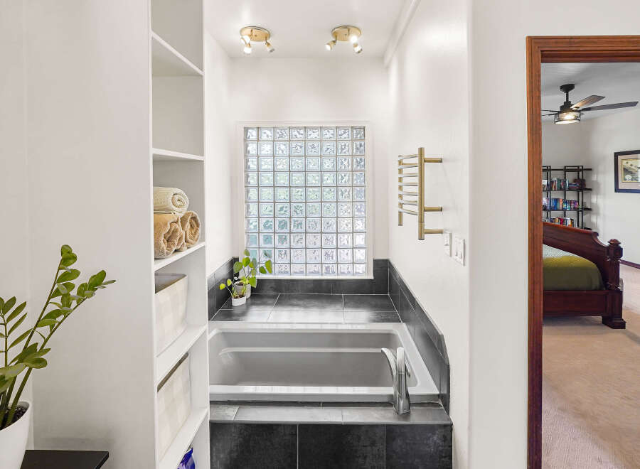 Step into a luxurious bathroom oasis! This stunning space features a sleek bathtub, perfect for unwinding after a long day.