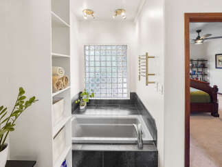 Step into a luxurious bathroom oasis! This stunning space features a sleek bathtub, perfect for unwinding after a long day.