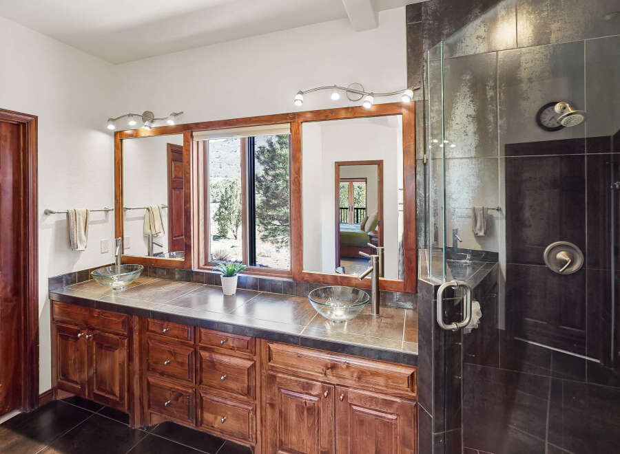 This luxurious bathroom features a stunning vanity with dual sinks, elegant cabinetry, and a large mirror.