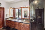 This luxurious bathroom features a stunning vanity with dual sinks, elegant cabinetry, and a large mirror.
