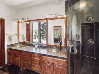 This luxurious bathroom features a stunning vanity with dual sinks, elegant cabinetry, and a large mirror.