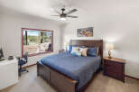 Step into this inviting bedroom, featuring a comfortable bed and a stunning view through the large window.