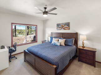 Step into this inviting bedroom, featuring a comfortable bed and a stunning view through the large window.