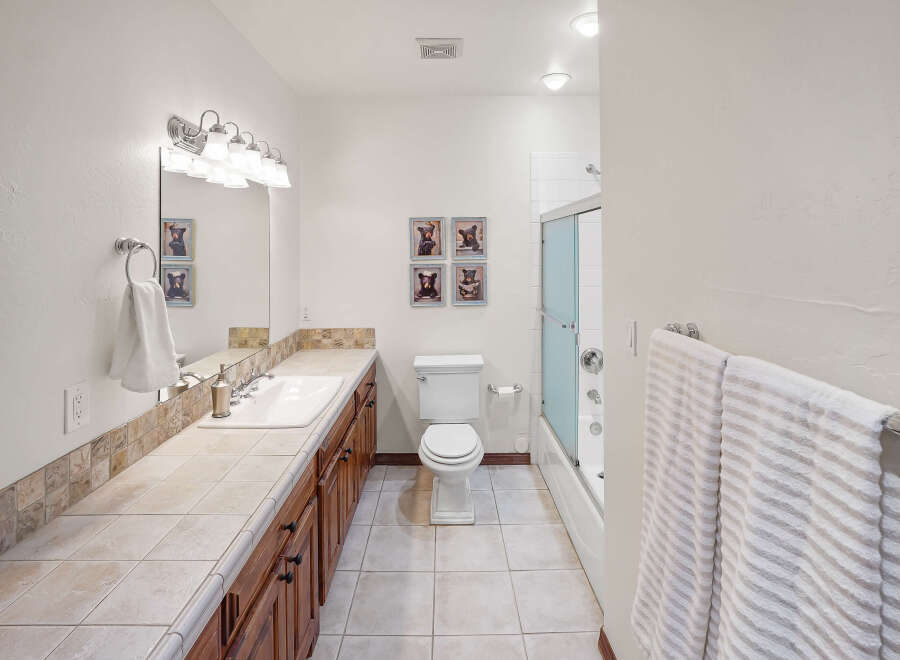 Step into this inviting bathroom, featuring a well-lit vanity area with a large mirror and ample counter space.