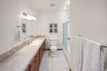 Step into this inviting bathroom, featuring a well-lit vanity area with a large mirror and ample counter space.