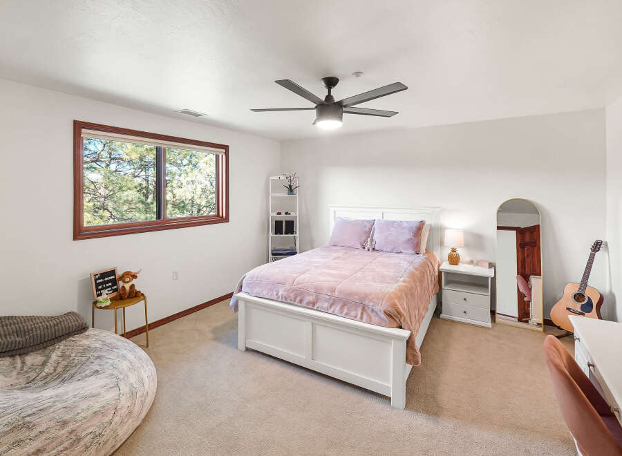 This inviting bedroom boasts a cozy atmosphere with its plush bedding and soft color palette.