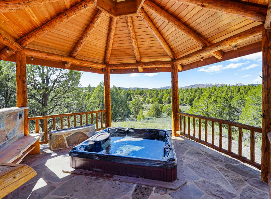 Relax and unwind in this stunning outdoor spa, nestled under a beautiful wooden gazebo.