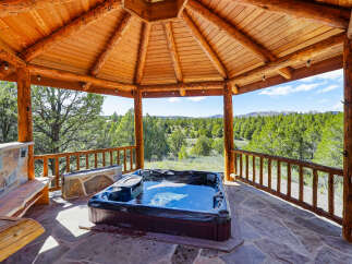 Relax and unwind in this stunning outdoor spa, nestled under a beautiful wooden gazebo.