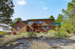 Nestled amidst lush greenery, this stunning property boasts a charming wooden exterior and a welcoming entrance.