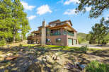 This stunning property boasts a spacious multi-level home with a beautiful stone chimney and a charming wooden deck.