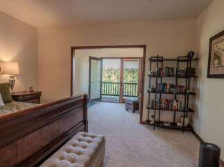 Experience breathtaking mountain views from this serene bedroom, featuring a private balcony accessible through double doors.