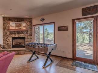 Experience ultimate relaxation and fun in this inviting living space, featuring a cozy stone fireplace and a thrilling foosball table.