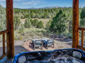 Experience ultimate relaxation with this inviting hot tub, perfectly situated to offer breathtaking views of the surrounding pine forest and distant mountains.