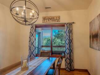 Experience breathtaking mountain views from this dining room, featuring a large sliding glass door that opens to a scenic balcony.