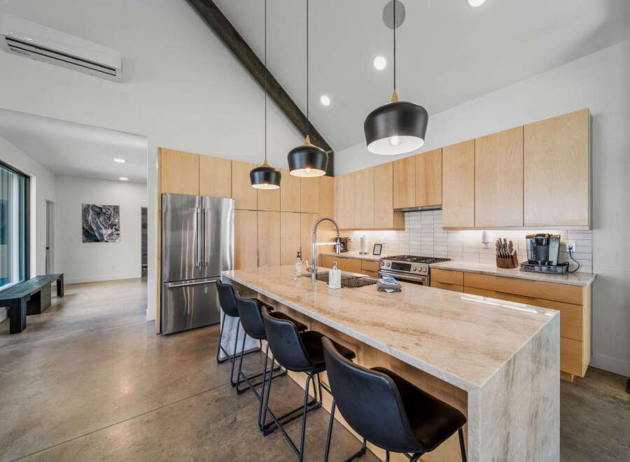 This stunning kitchen boasts a modern design with sleek cabinetry and a spacious island, perfect for both cooking and entertaining.