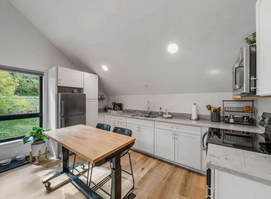This modern kitchen boasts a sleek design with white cabinetry and a stunning marble countertop.