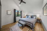 This stunning bedroom boasts a modern design with a vaulted ceiling and ample natural light.
