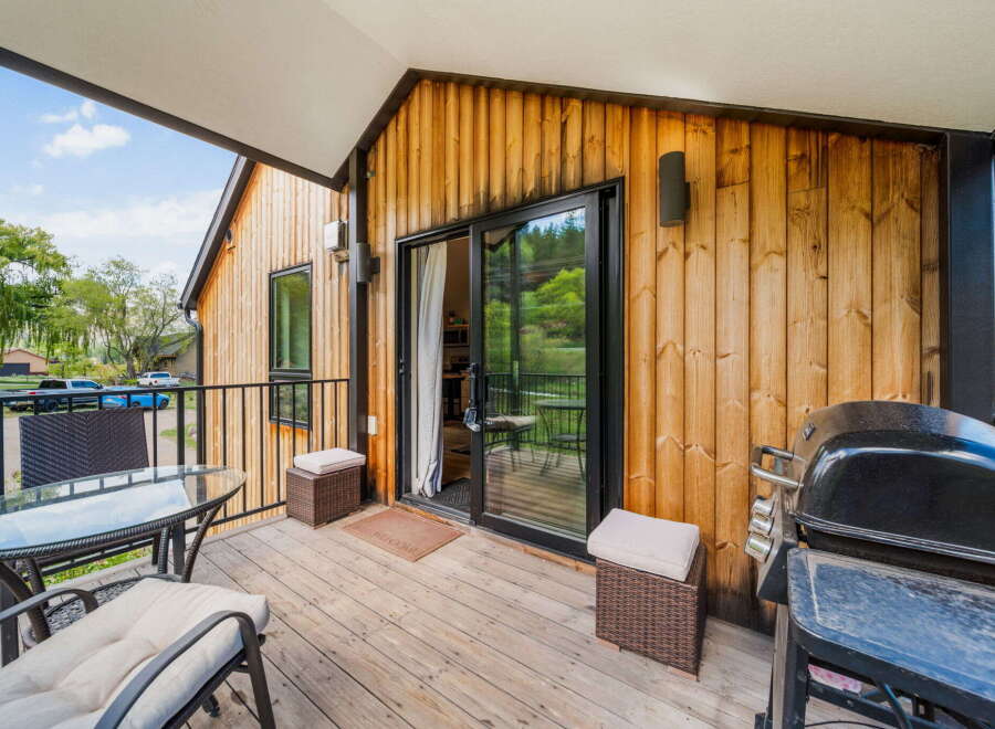 Enjoy outdoor living at its finest with this stunning deck featuring a built-in grill and comfortable seating.