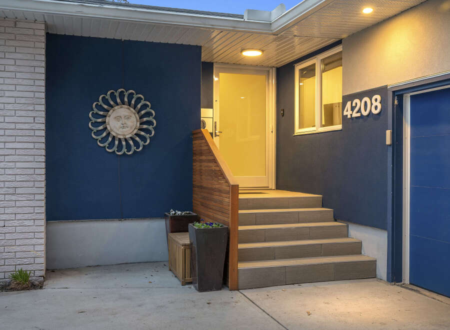 Discover the charm of this stunning property! Featuring a welcoming entrance with a stylish sunburst wall decor and a modern blue exterior, this home offers curb appeal.