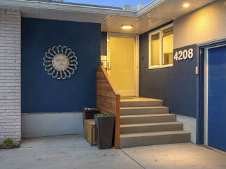 Discover the charm of this stunning property! Featuring a welcoming entrance with a stylish sunburst wall decor and a modern blue exterior, this home offers curb appeal.