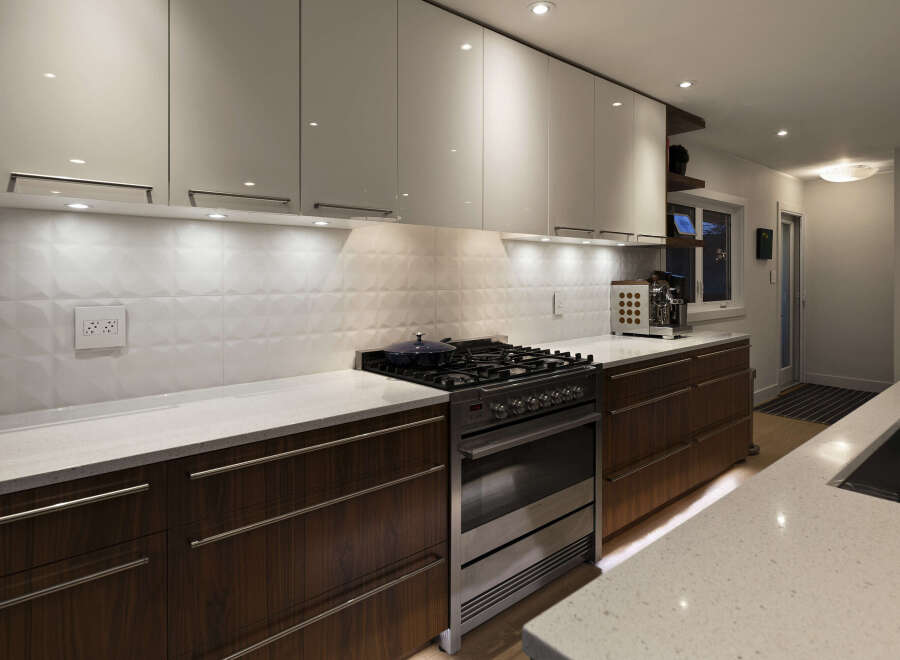 This modern kitchen boasts sleek white cabinetry and warm wood accents, creating a stylish and inviting space.