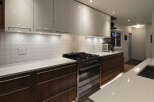 This modern kitchen boasts sleek white cabinetry and warm wood accents, creating a stylish and inviting space.