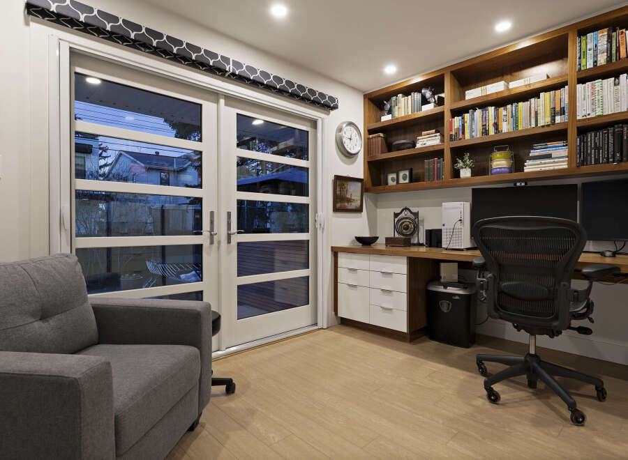 Step into this stylish home office, featuring a built-in desk and shelving, perfect for productivity.