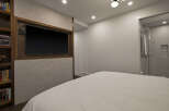 This modern bedroom features a sleek design with a built-in entertainment center, perfect for relaxing.