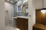 Step into a modern bathroom oasis, featuring a sleek vanity with ample storage and a stylish round mirror.