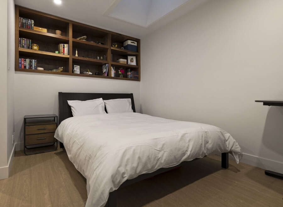 This cozy bedroom features a built-in bookshelf, perfect for displaying your favorite books and decor.