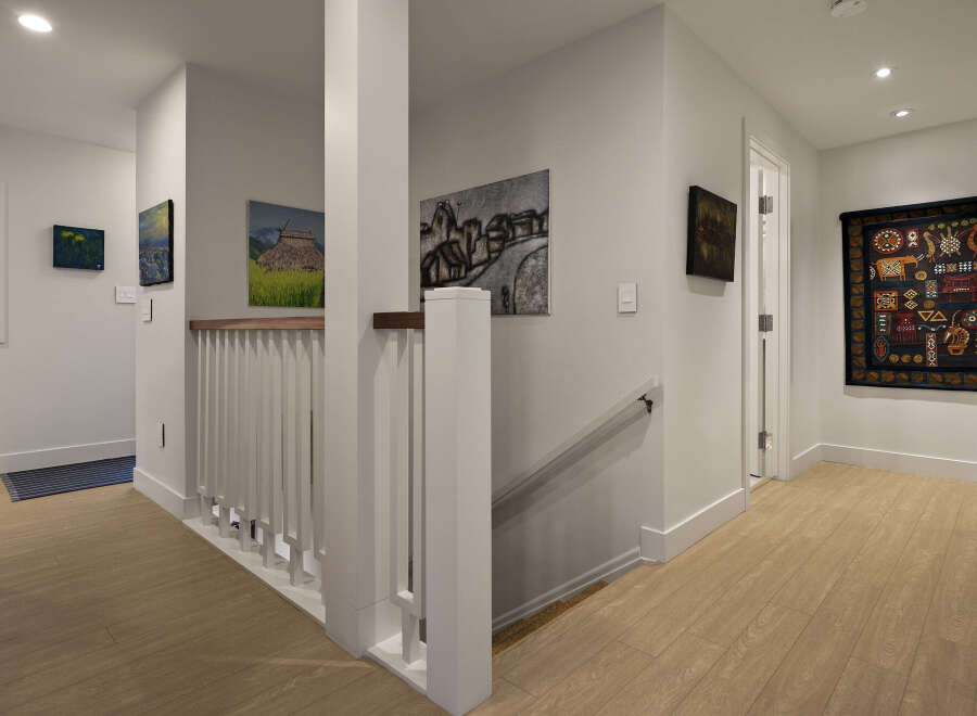 This stunning property boasts a beautifully designed hallway with hardwood floors and a modern aesthetic.