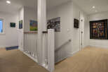 This stunning property boasts a beautifully designed hallway with hardwood floors and a modern aesthetic.