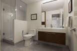 This modern bathroom features a sleek design with a glass-enclosed shower and a floating vanity.