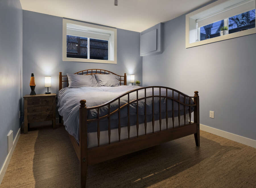 This cozy bedroom offers a serene retreat with its calming blue walls and natural wood accents.