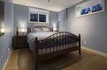 This cozy bedroom offers a serene retreat with its calming blue walls and natural wood accents.