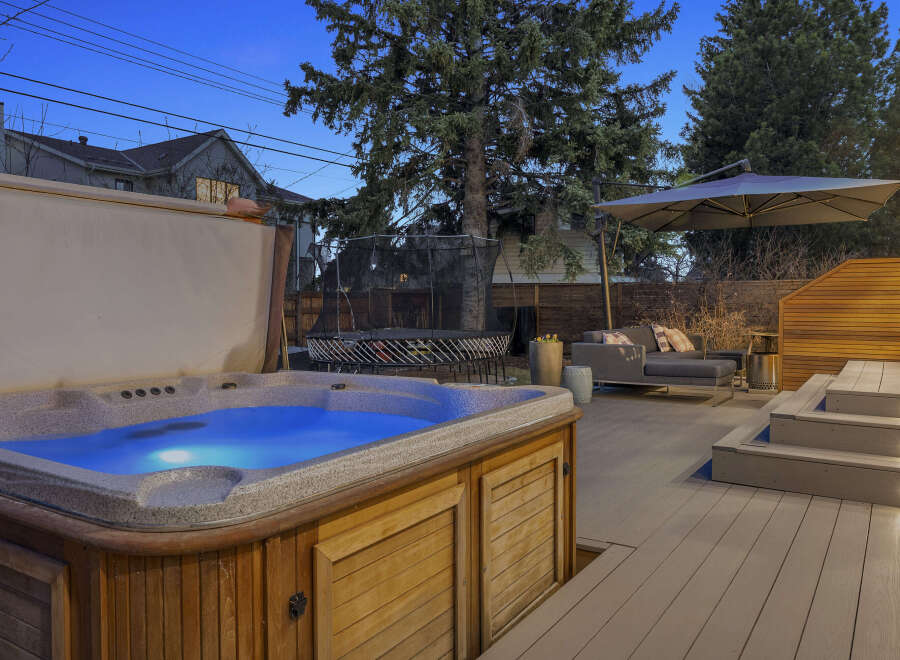 Enjoy luxurious outdoor living in this stunning property! Featuring a beautiful hot tub, a spacious deck, and a comfortable seating area, this home is perfect for relaxation and entertaining.