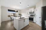 This stunning kitchen boasts a modern design with sleek white cabinetry and a spacious island, perfect for meal preparation and entertaining.