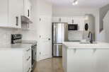 This stunning kitchen boasts modern design with sleek white cabinetry and stainless steel appliances.