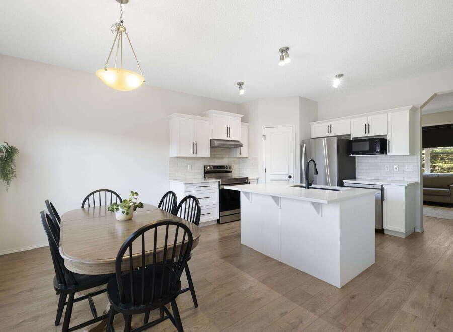 This stunning kitchen and dining area offers a bright and inviting space for both cooking and entertaining.