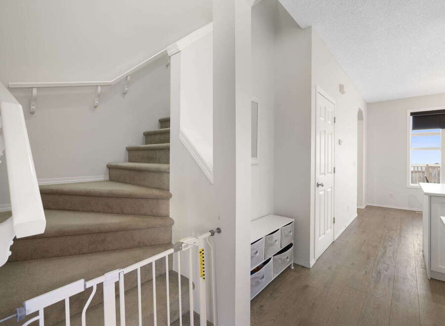 Step into this inviting home featuring a staircase with carpeted steps and a safety gate, perfect for families.
