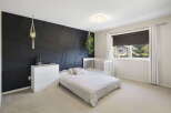 This stunning bedroom features a modern design with a striking black accent wall.