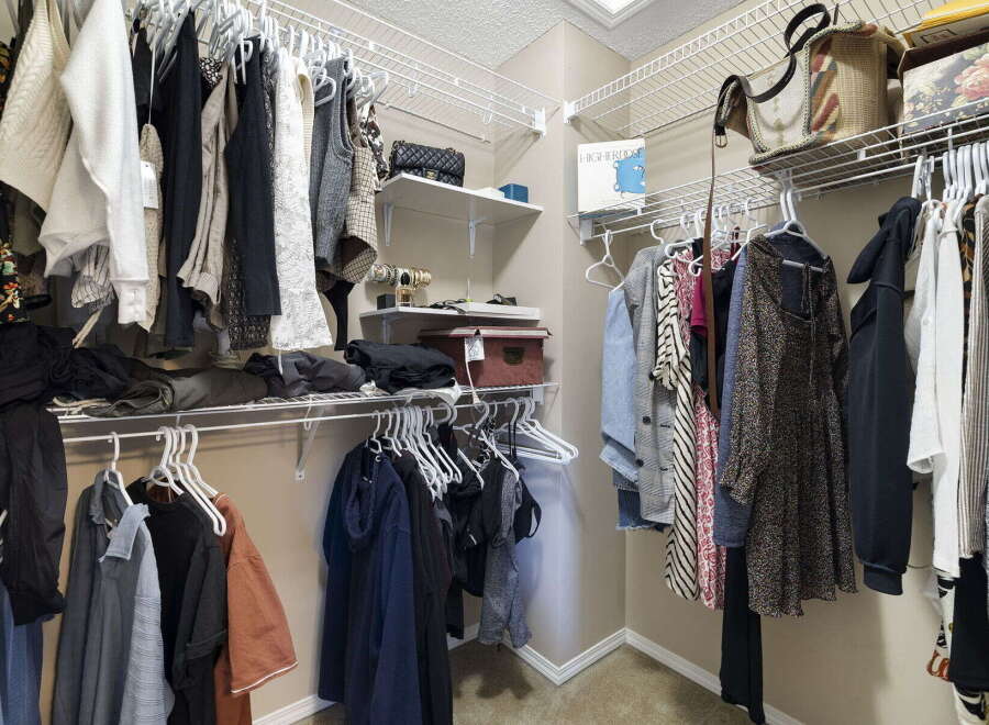 Step into this organized walk-in closet, a perfect addition to any home.