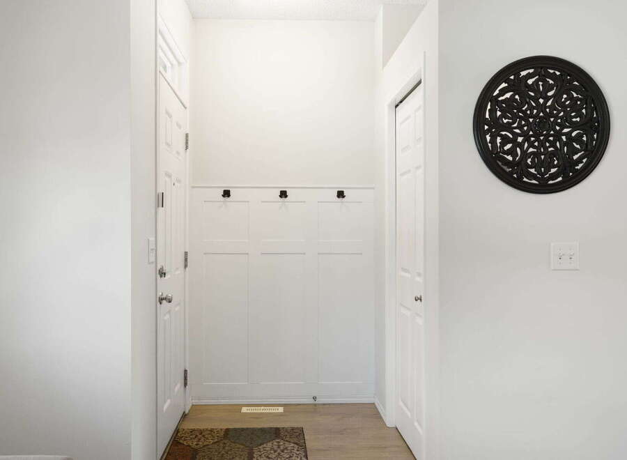 Step into this inviting entryway, featuring a stylish coat rack and a decorative wall accent.